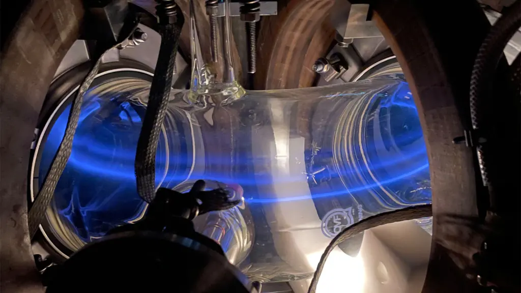 A glowing blue light contained within a large metal donut shape.