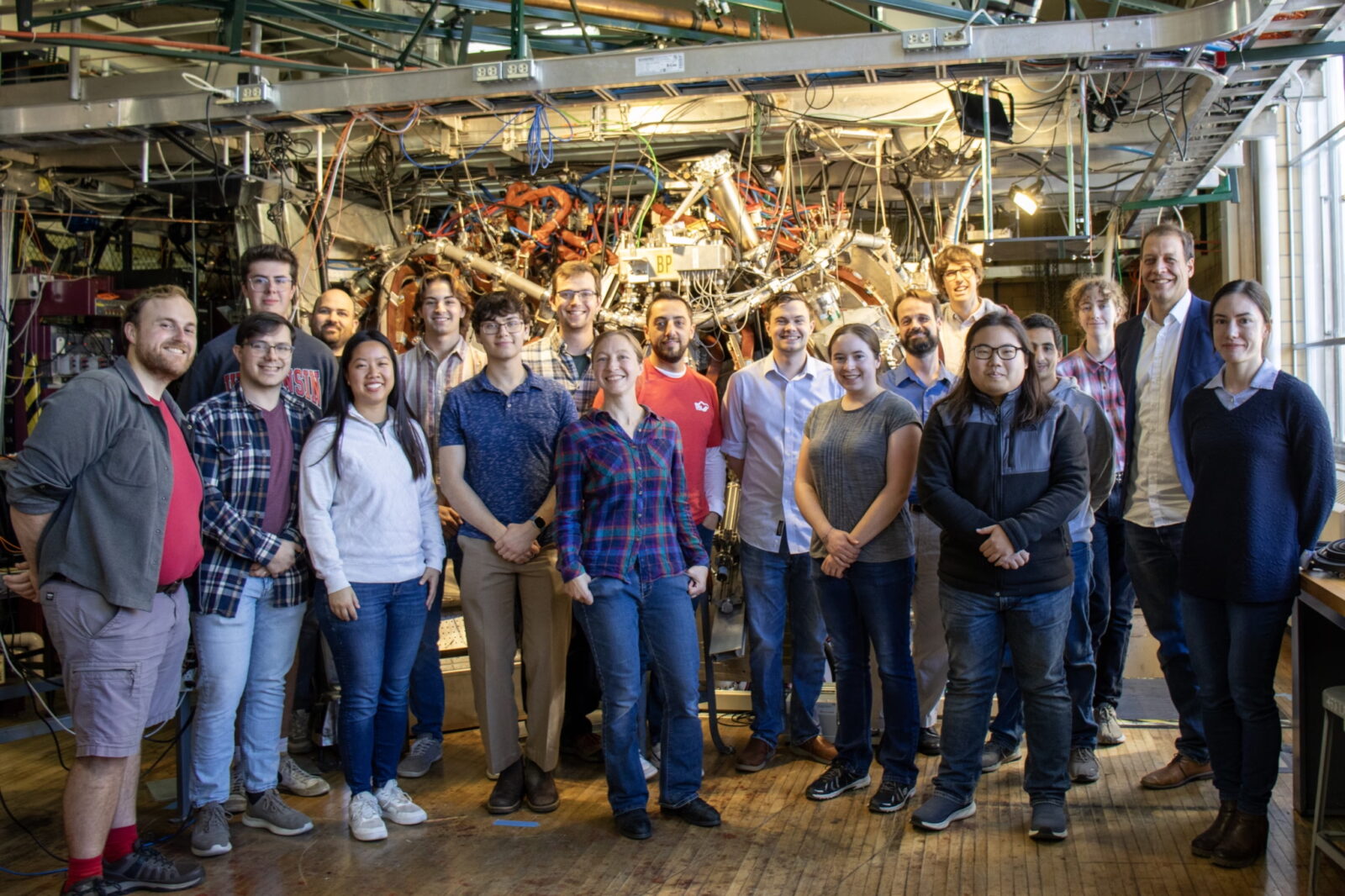 large group of people standing in front of a complex fusion energy device