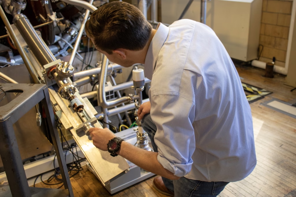 person working closely on a piece of scientific equipment