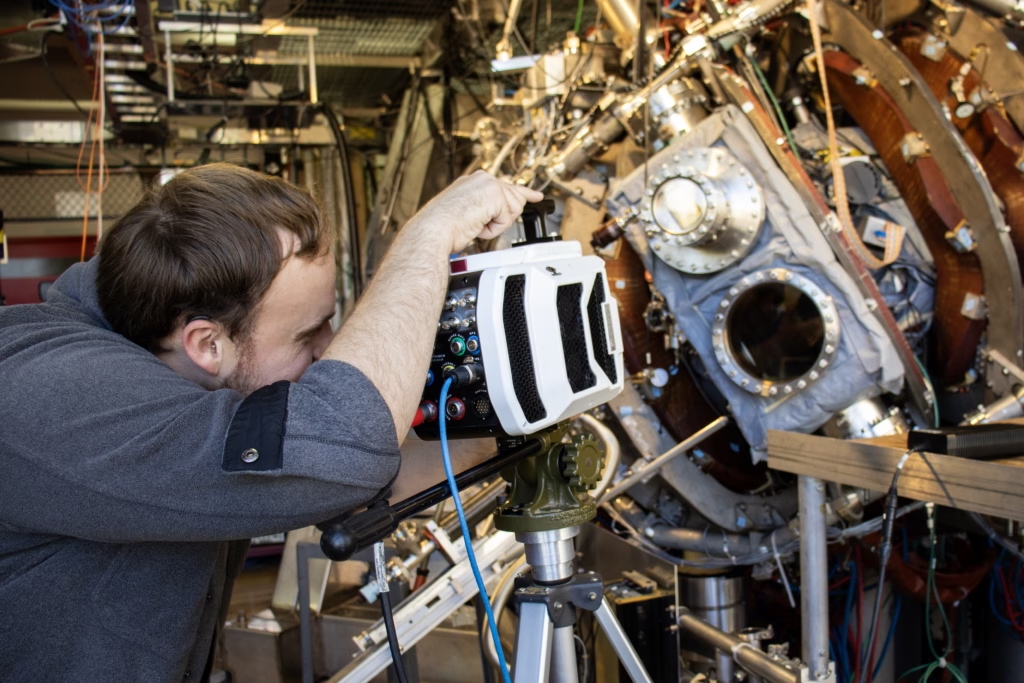 person working closely on a piece of scientific equipment