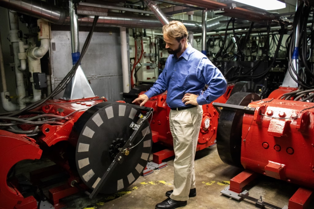 person standing next to a large piece of scientific equipment
