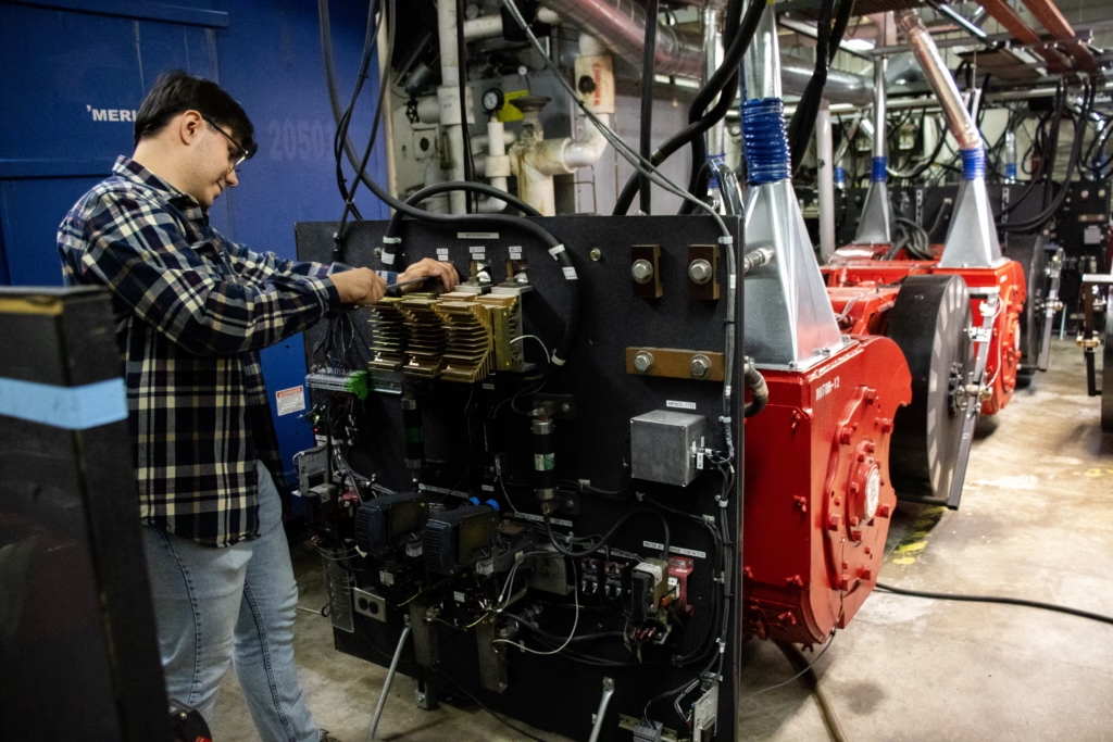 person working closely on a piece of scientific equipment