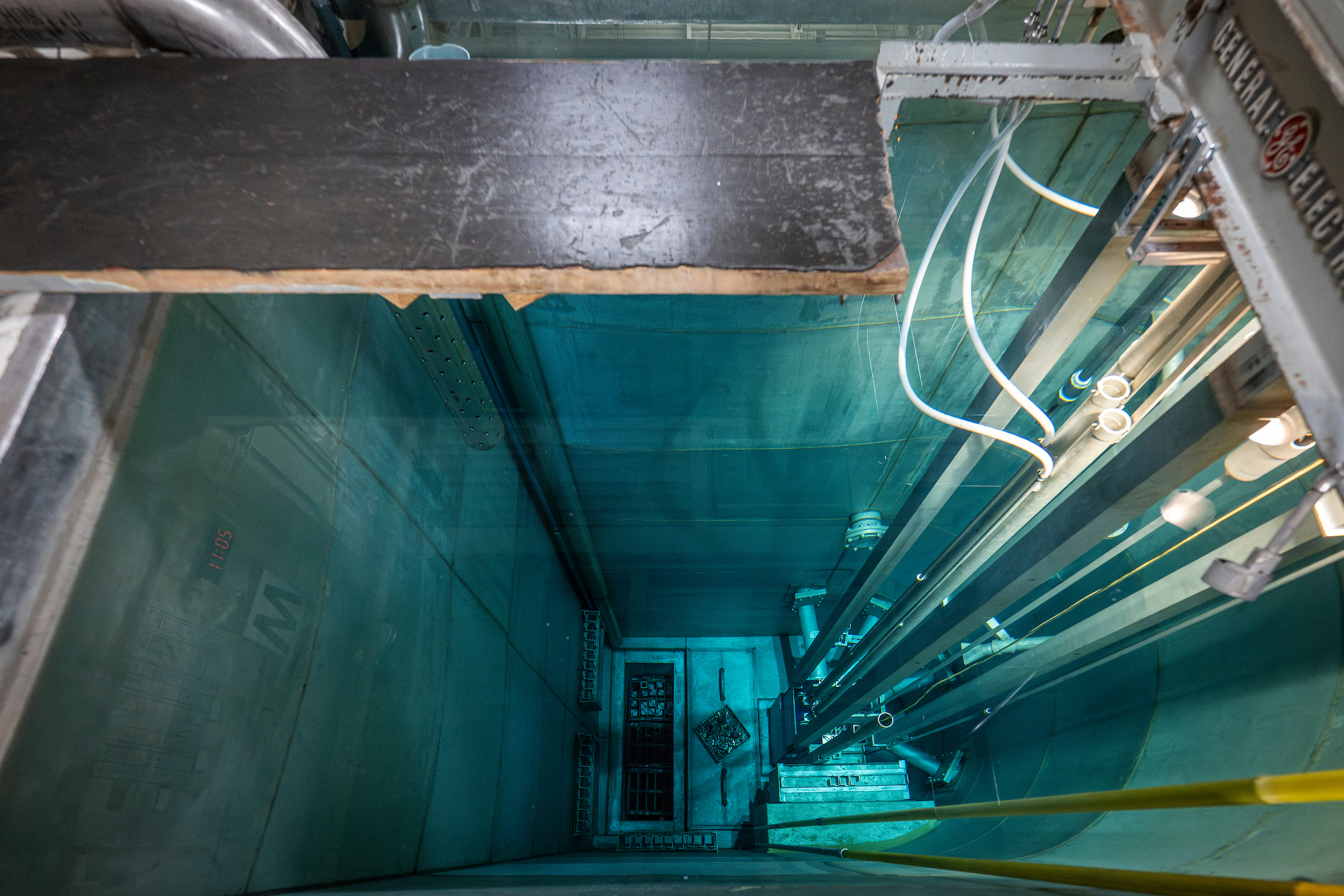 looking down into a deep pool with piping along the side