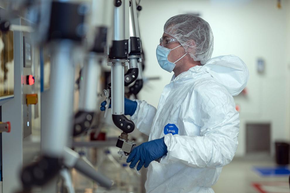 person wearing PPE working on a large piece of equipment